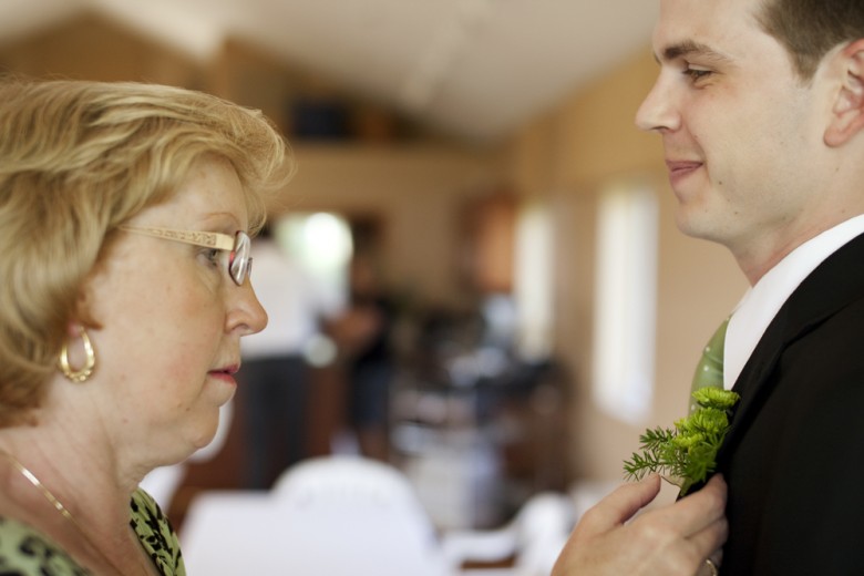 Mom pinning a boutonnière on Jon (Photo by Marni Mattner Photography)